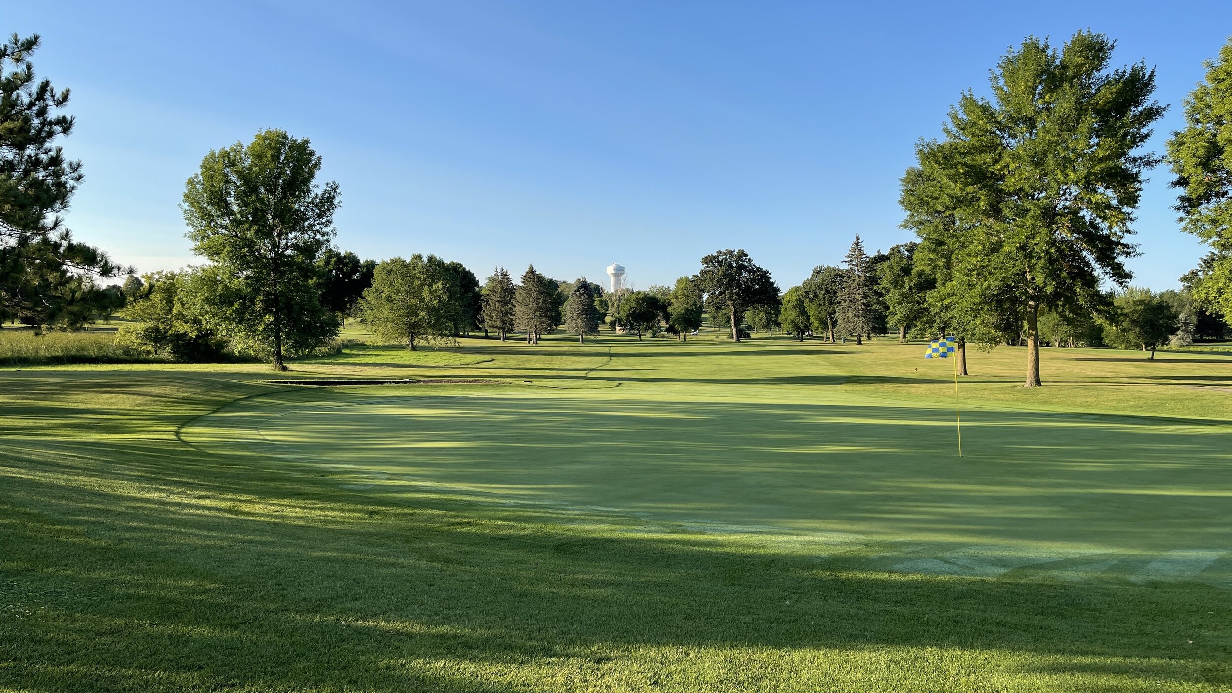 A green framed by mature trees at Montgomery National Golf Club