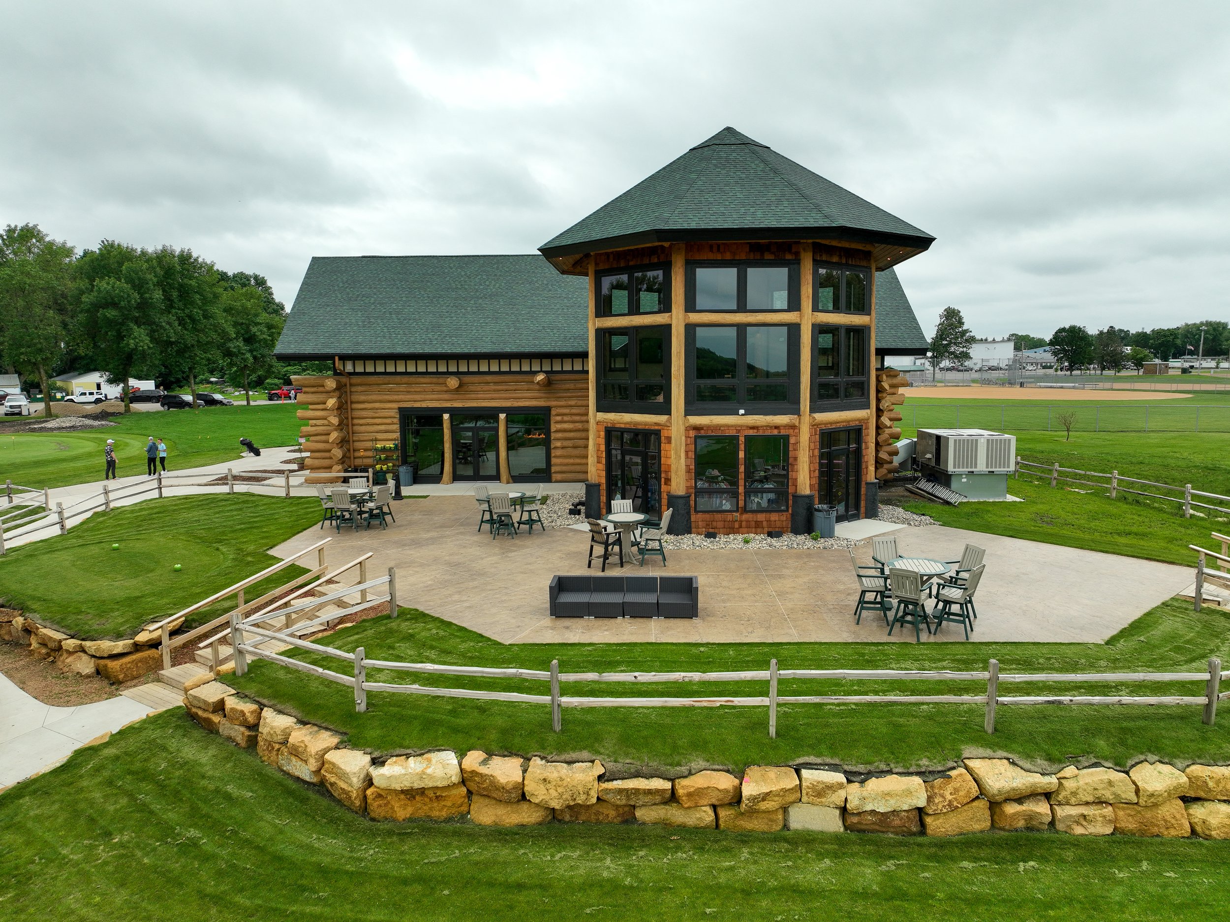 The log cabin clubhouse and its stone-edged patio at Montgomery National, seen from a drone