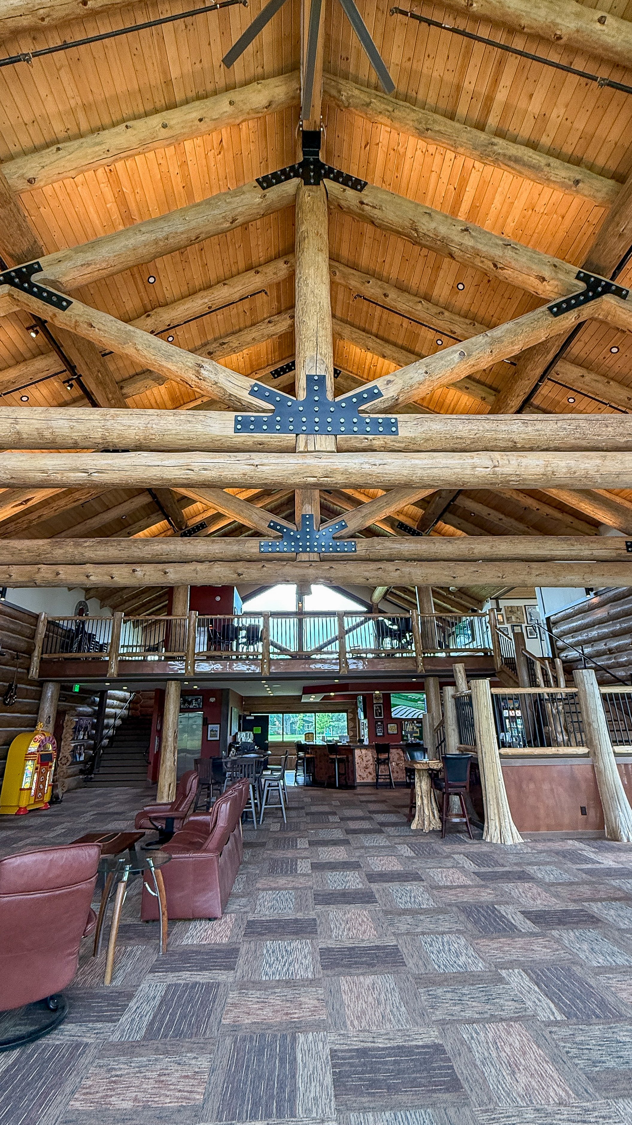 The lower-level great room with leather seating, the bar and the upper-level balcony above