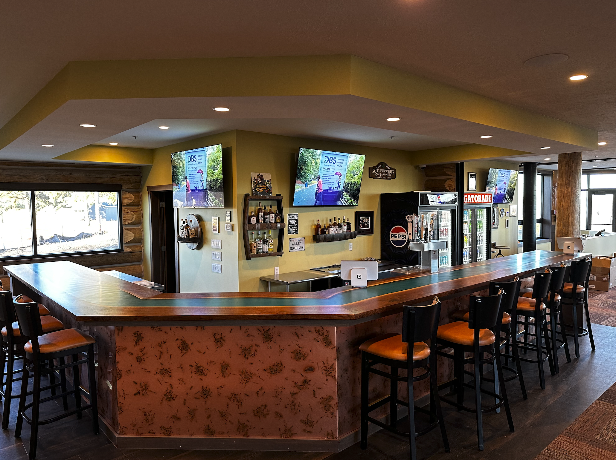 The clubhouse bar with bar stools, drink coolers and TVs
