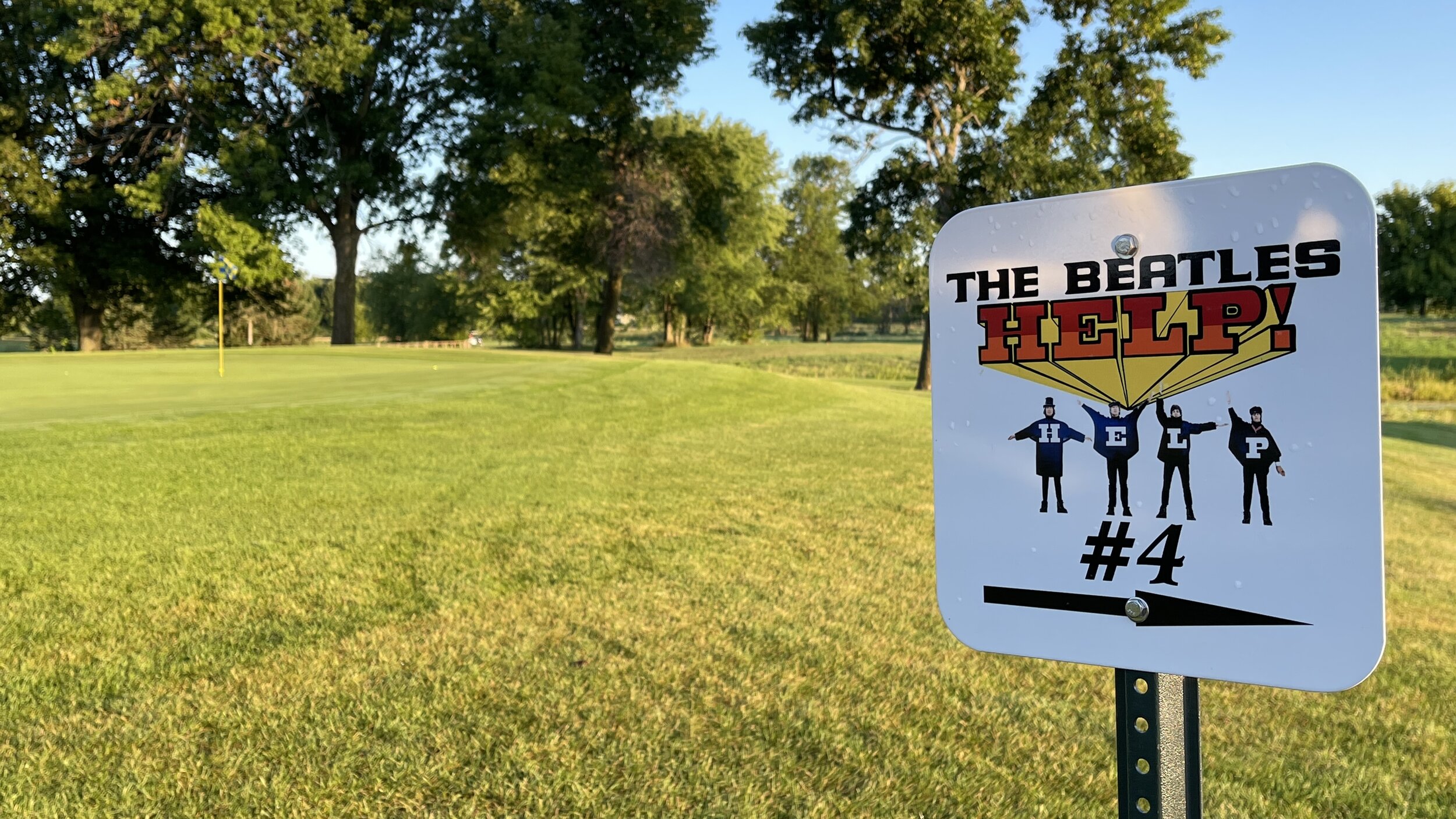 A Beatles "Help!" sign marking hole 4 beside a fairway at Montgomery National